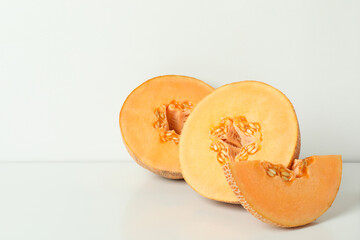 Ripe melon slices on white table, space for text