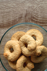 Bowl of biscuits on wooden table. Top view.