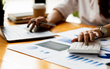 Close up of Business woman accountant or financial expert analyze business report graph and finance chart at corporate office. Concept of finance economy, banking business and stock market research. 