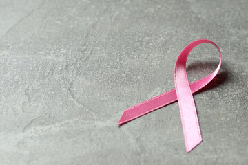 Breast cancer awareness ribbon on gray textured background