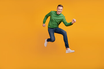 Fototapeta na wymiar Portrait of crazy nice attractive cheerful sporty guy jump run look camera on yellow background