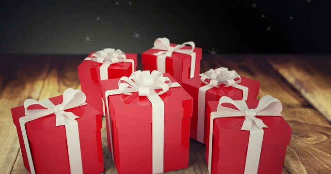 Animation of snow falling over christmas presents on wooden and black background