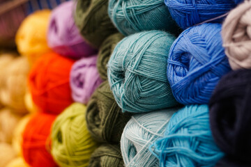 Many colorful yarn for handmade knitting in a needlework shop.
