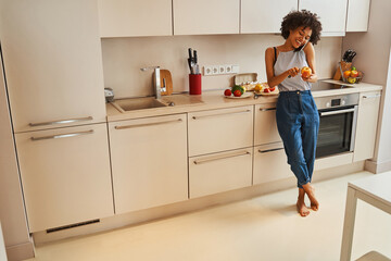 Smiling lady peeling the fruit during the phone conversation