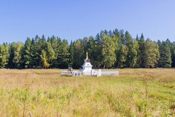 Sunny view on ritual Buddhist stupa Enlightenment against forest near Krasnoyarsk, Russia