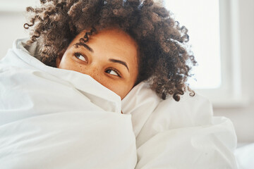 Pensive dark-haired woman with thick curly dark hair looking away