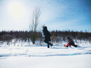 Mother pulling girl sitting in sled