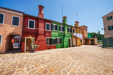 Burano island, houses with bright colors and clothes hanging on clotheslines to dry in the sun. Venetian lagoon, Venice, UNESCO world heritage site, Veneto, Italy, Europe.