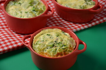 Healthy snack Broccoli  with eggs cheddar cheese and thyme close-up in mini casserole .