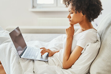 Serious female freelancer staring at her portable personal computer