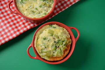 Healthy snack Broccoli  with eggs cheddar cheese and thyme close-up in mini casserole .