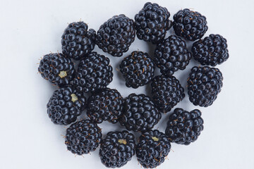 Ripe blackberries small fruits close up on white background, flat lay, copy space.