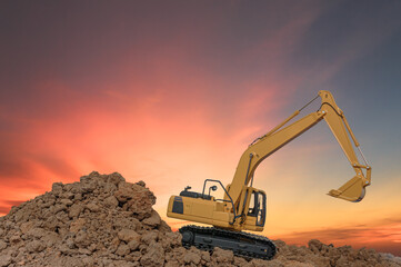 Fototapeta na wymiar Crawler excavator digging the soil In the construction site on orange sky background