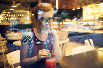 woman with short hair sitting at a table in a cafe cocktail drink loneliness