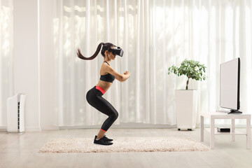 Full length profile shot of a young woman exercising with a vr headset in front of tv