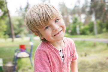 close-up portrait of a cute boy 5 years old walking in the park in the summer. Happy childhood,...