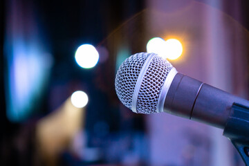 Close-up of microphone for singing on stage with lights in the background
