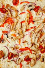 Pizza with vegetables and chicken. A mouth-watering traditional Italian dish. Close-up. Vertical.