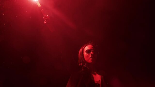 independent woman holding flare in city at night rebellious girl protesting for equality in street with firework female millennial freedom movement