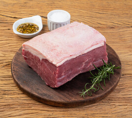 Raw ancho beef, typical argentinian cut, over wooden board with seasonings