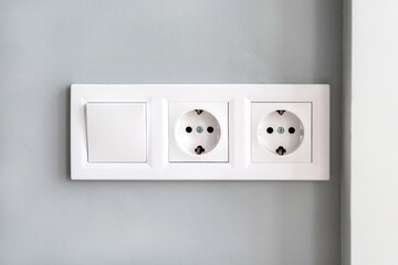 White european electrical outlets and switch on gray wall - obrazy, fototapety, plakaty