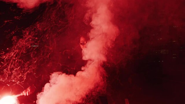 woman dancing with flare in city at night rebellious girl protesting in street with firework female millennial freedom movement