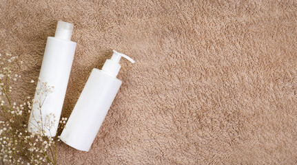 Bathroom cosmetics. Personal hygiene starter kit on a towel and tile. Top view flat lay with copy space bottles. Mockup text template photo