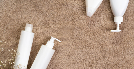 Bathroom cosmetics. Personal hygiene starter kit on a towel and tile. Top view flat lay with copy space bottles. Mockup text template photo