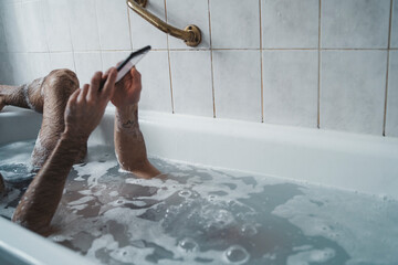 close up man holding the phone with his head underwater