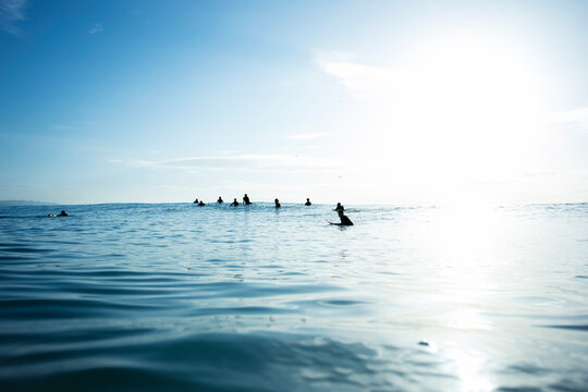 surfers waiting for a wave, in the sea, surf, sky