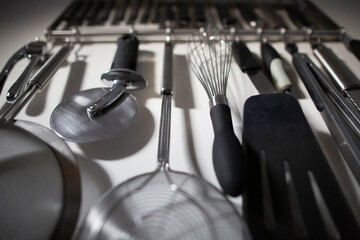 Group of Organized Kitchen Tools Hanging on Home Kitchen Wall