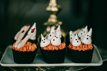Closeup of spooky Halloween decorations, cupcakes with ghosts and fingers