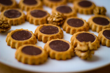 round shortbread cookies poured with chocolate on a white plate