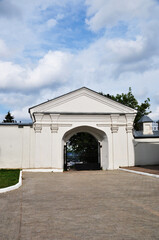 Obraz premium Large arch with metal gates. Entrance to the territory of the monastery. Arch with half columns.