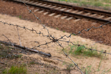 Barbed wire on the background of the railway track - Powered by Adobe