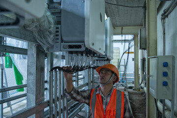 engineer or electrician holding laptop for inspect and checking string inverter by wifi technology ;smart technology for operate solar power plant