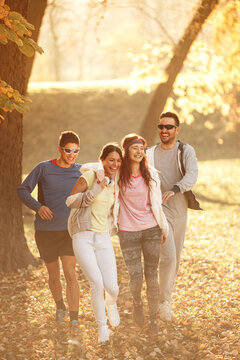 Group of friends in sportswear jogging at the park on beautiful day.Autumn concept.