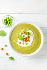 classic split pea soup with roasted chickpeas on wooden background. Top view, copy space.