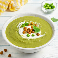 Green pea vegetable soup puree on wooden background. Copy space.