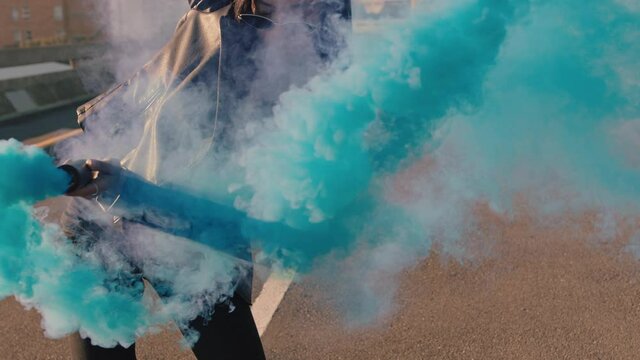 dancing woman waving blue smoke grenade in city street hip hop dancer girl celebrating creative freedom with dance slow motion