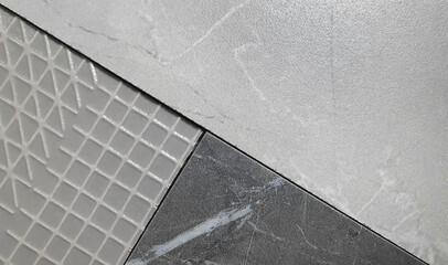 close up interior stone and pattern tile samples consists grey emperado marble, black marble, graphic pattern textures. combination of floor or wall tile collection in grey tone for luxury style.