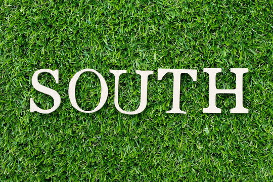 Wood alphabet letter in word south on green grass background