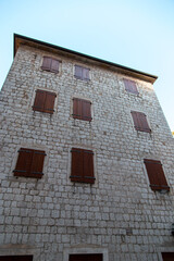Windows with shutters on an old stone house, old architecture.