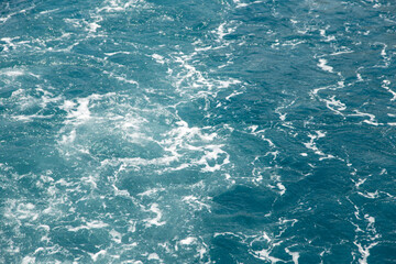 Bubbling water and sea foam from the motor of the boat, concept of water movement, gravel sea color.