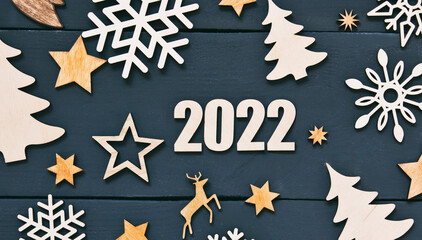 The beautiful christmas background with a lot of small wooden decorations and wooden numbers 2022...
