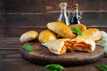 Traditional Russian cabbage pies on wooden background. Baked homemade pirozhki with cabbage
