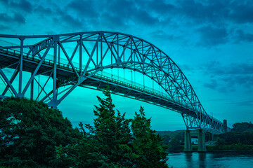 Turquoise colored blue landscape over Sagamore Bridge and Cape Cod Canal at night during the blue hour