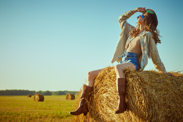 hippie girl on a haystack - obrazy, fototapety, plakaty