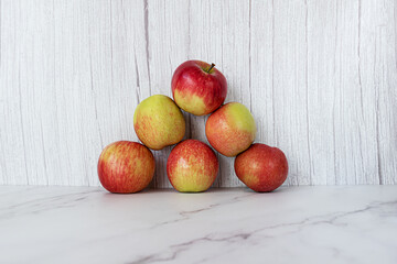 A pyramid of red apples on a light background.