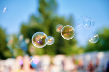 Beautiful soap bubbles at the park on a sunny day. A lot of bubbles in the air. Blurred background....